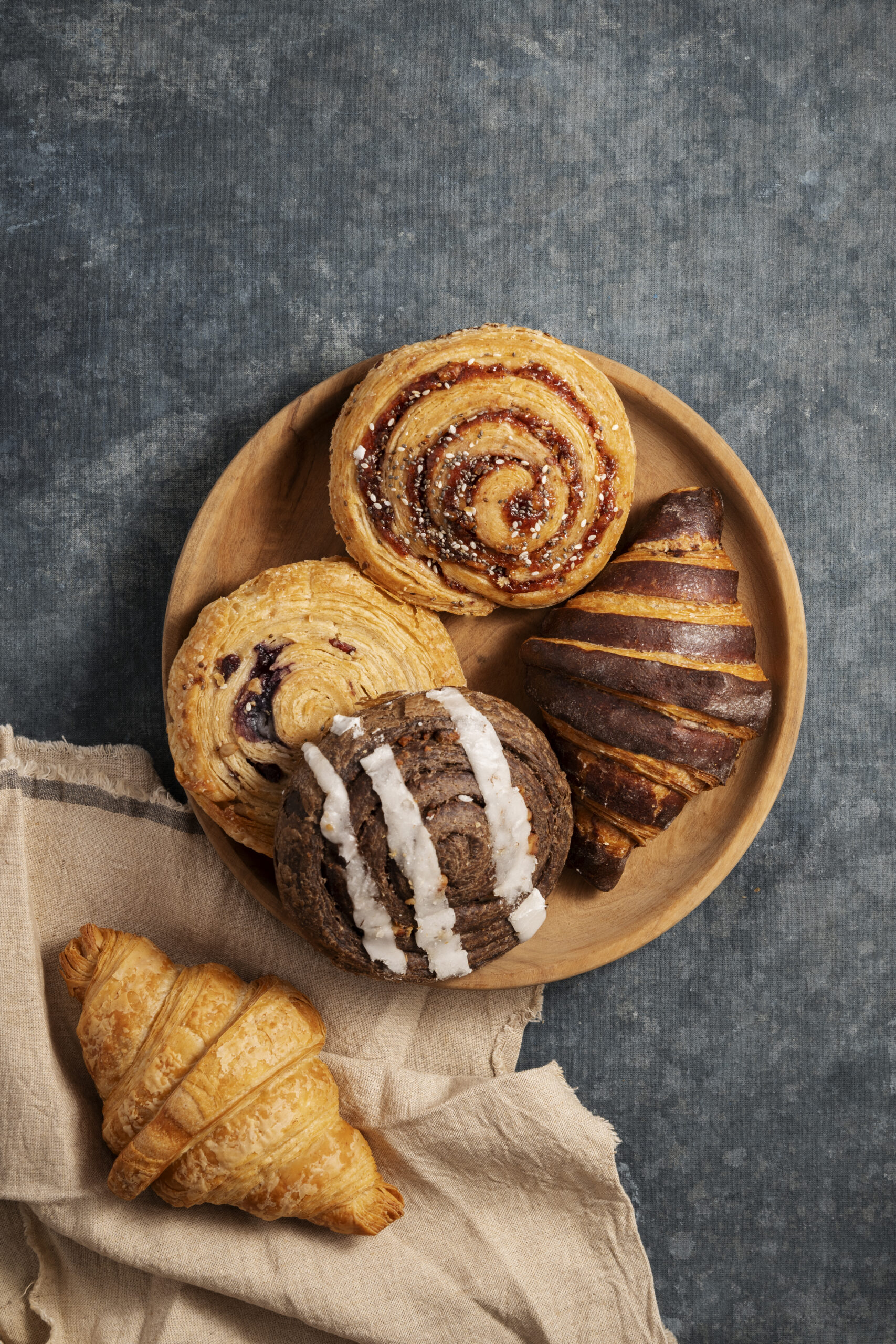 crossaint, cookies in a brown plate just like home baked.